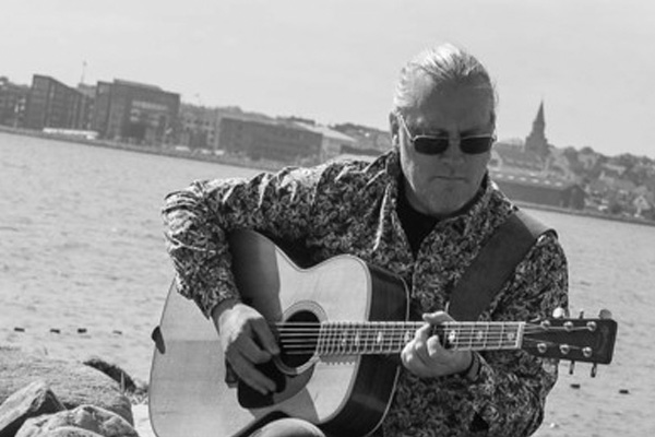 Guitar Guy, Claus Schlütter spiller ved fjorden, med udsigt til holbæk i baggrunden